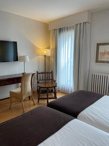 普韦布拉桑纳比亚普韦布拉德萨纳夫里亚旅馆的酒店客房配有一张床、一张书桌和一台电视。