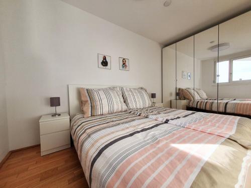 维也纳Near Lake Stylish & Fully Furnished Apartment的一间卧室配有一张带条纹毯子的大床