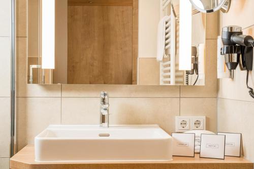科隆弗朗德舍尔霍夫酒店的浴室设有白色水槽和镜子