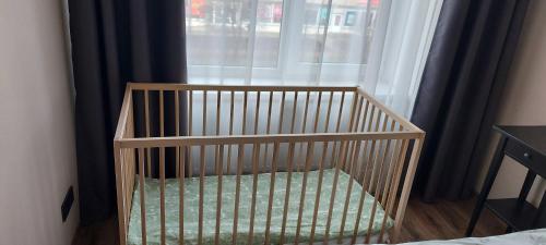 雷泽克内Elen White Apartment的窗户房间里一张婴儿床