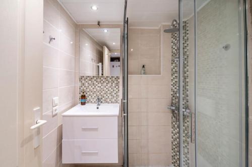 马赛Studio idéal pour deux voyageurs sur Marseille的一间带水槽和玻璃淋浴的浴室