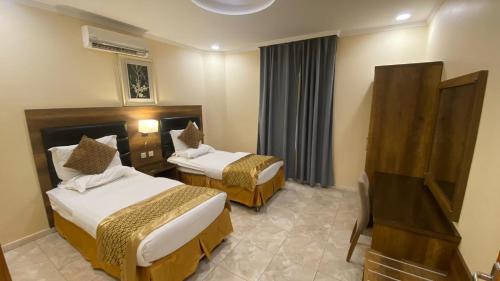 阿尔莎法Almasakin Alfakhira的酒店客房设有两张床和电视。