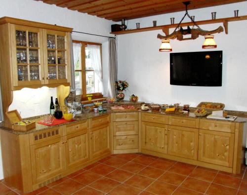 巴特维塞克里斯托夫旅馆的一间带木制橱柜和平面电视的厨房