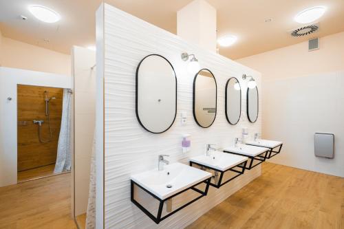 布拉格Luma Terra Prague Hostel的浴室里一排带镜子的盥洗盆