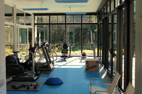 科特赖克Villa Pura Vida的一间健身房,铺有蓝色的地板,设有大型玻璃窗