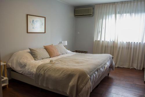 门多萨Casa Reconquista的一间卧室设有一张大床和窗户