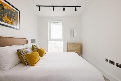 伦敦CitySpace Acton的白色卧室配有一张带黄色枕头的大床