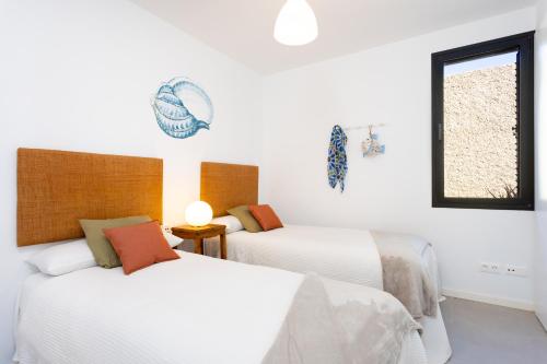 波里斯-德阿沃纳Home2Book Design & Breathtaking Sea Views El Porís的配有2张床的白色墙壁和窗户。
