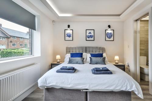 谢菲尔德Large, Modern Apartment with En-suites, Wifi, Parking by Ark SA的一间卧室配有一张大床和两个枕头