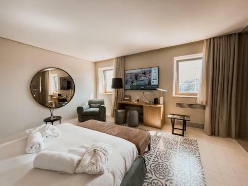 特拉尼Ognissanti Restaurant Spa Hotel Rooftop的配有一张大床和镜子的酒店客房