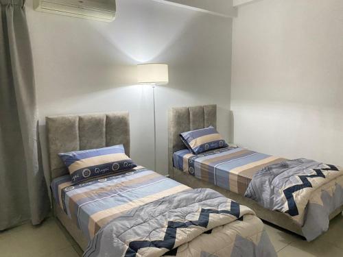 Kampong Lumut Kiri休闲民宿 Leisure Homestay @The Venus Sitiawan的一间卧室配有两张床和一盏灯。