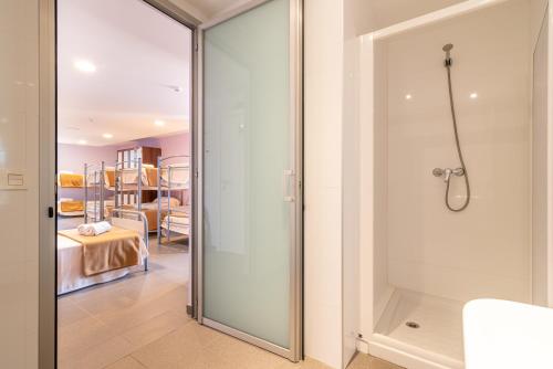 塞利亚Albergue "El Río"的卧室浴室内的玻璃淋浴间门