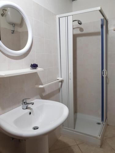 罗迪-加尔加尼科Dal Cavallaro的浴室配有盥洗盆和带镜子的淋浴