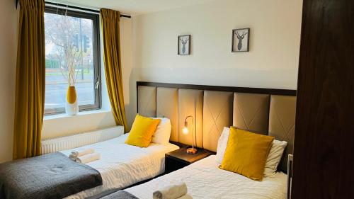 伯明翰Naps Inn的一间卧室配有两张带黄色枕头的床和窗户。