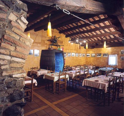 瑞达里那马略齐内斯旅馆的一间带桌椅和石墙的用餐室