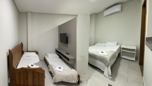 博尼图Confort Flats的小房间设有两张床和电视