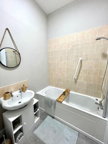 亚历山德里亚Stevenson Apartment的一间带水槽、浴缸和镜子的浴室