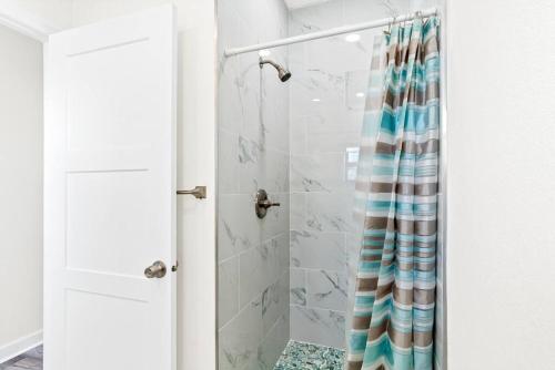 克利尔沃特Dolphin Watch的浴室设有带条纹淋浴帘的淋浴