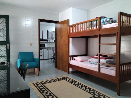 库里提巴Pousada Casa Verde - Curitiba的一间卧室配有两张双层床和一张蓝色椅子