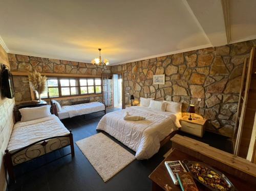 伊夫兰莱斯因瓦勒旅馆的一间卧室设有两张床和石墙