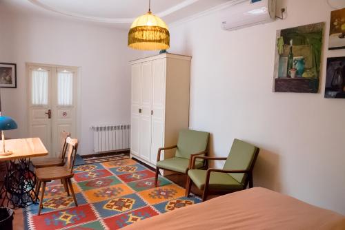 撒马尔罕Old Radio hostel的一间设有两把椅子、一张桌子和一张桌子的房间