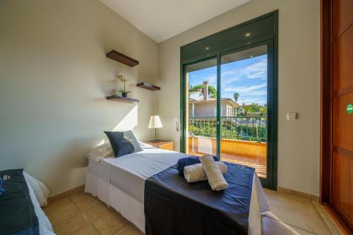 罗列特海岸VIlla Jaruco Lux, exclusiva zona residencial con Piscina & Aircon的一间卧室设有一张床和一个大型玻璃窗