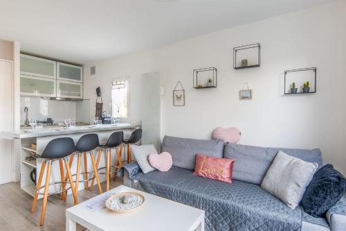 卡布尔Charming duplex with big terrace- Cabourg - Welkeys的一间带蓝色沙发的客厅和一间厨房