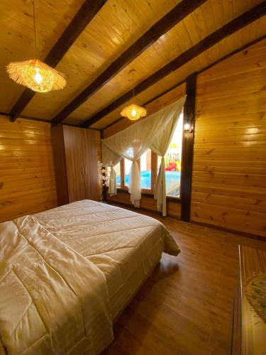As Sayl aş Şaghīrبلفيو كوخ的一间带一张大床的卧室,位于带木墙的房间