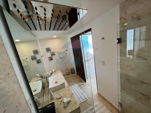 普拉亚卡门Anah Downtown luxury condo的一间带水槽、淋浴和镜子的浴室