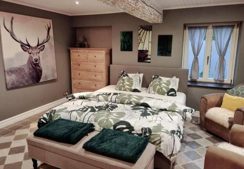 SartMaison typique privée - Sart Lez Spa - PINE COTTAGE- charme piscine的卧室配有一张床,墙上挂着鹿画