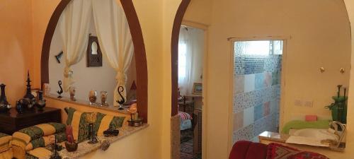 穆莱伊德里斯Riad lala zakia的一间带镜子的客厅和一间浴室