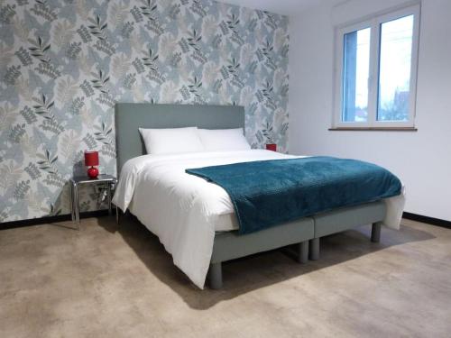 ArdresAux Portes des Lacs的一间卧室配有一张带蓝色毯子的床