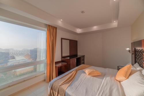 瓦迪穆萨Petra Elite Hotel的一间卧室设有一张床和一个大窗户