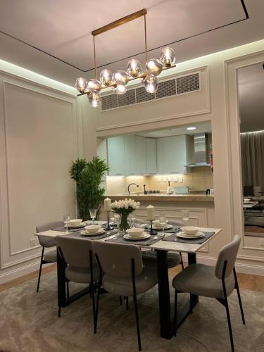 多哈Beachfront Luxury Apartment-The Home-Pearl Island的一间带桌椅的用餐室和一间厨房