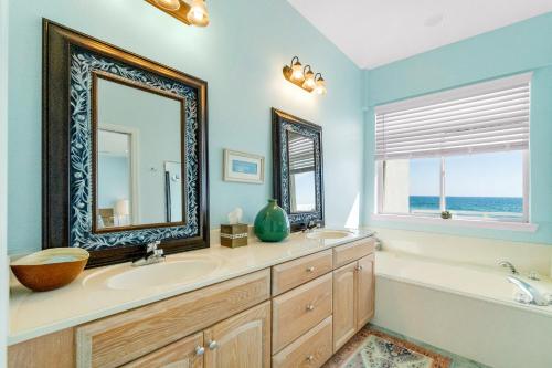 彭萨科拉海滩Turtle Ridge的浴室设有镜子、浴缸和水槽
