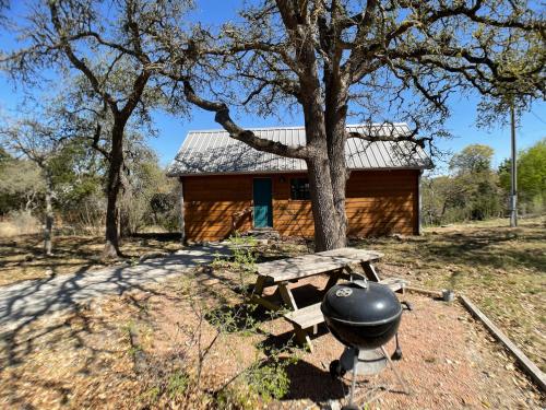 弗雷德里克斯堡Walnut Canyon Cabins的小木屋前的烧烤和野餐桌