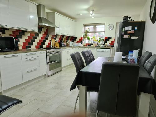 BuckinghamshireHomely Home的厨房配有桌椅和冰箱。