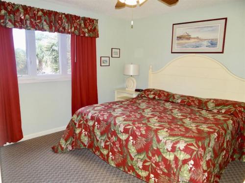 默特尔比奇Deerfield Plantation 217A2的一间卧室配有一张红色床罩的床