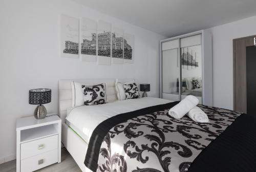 布加勒斯特Lion's Unirii Apartment的黑白卧室设有床和床头柜