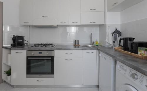 布加勒斯特Lion's Unirii Apartment的白色的厨房配有炉灶和水槽