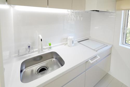 二世古NISEKO EPIC HOUSE的白色的厨房,配有不锈钢水槽