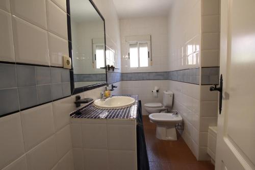 拉曼加戴尔马尔梅纳CHALET CON PISCINA A 100m DE LA PLAYA LA MANGA的一间带水槽、卫生间和镜子的浴室