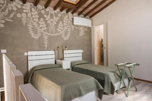 CapannucciaFAETOLE typical Tuscan country house near FLORENCE的一间卧室配有两张床和壁画