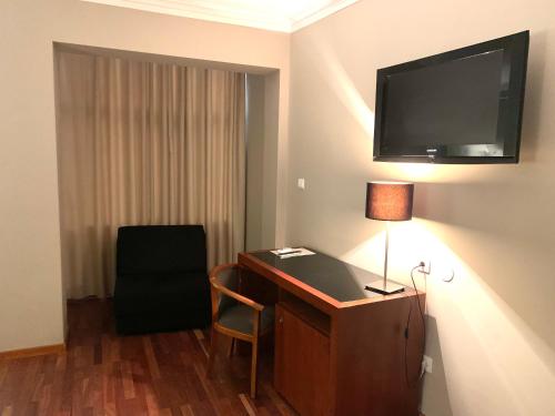 马亚美洲狮旅馆的酒店客房设有一张桌子和一台墙上的电视