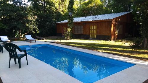 卢汉德库约Entrepinos Mendoza的小屋旁带椅子的游泳池