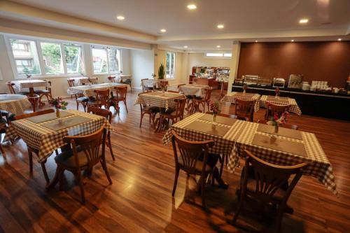 格拉玛多Hotel Querência的一间在房间内配有桌椅的餐厅