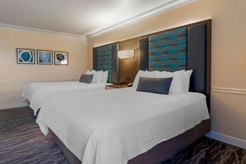 诺瓦托贝斯特韦斯特普拉斯诺瓦托奥克斯酒店的酒店客房内设有两张大型白色床。