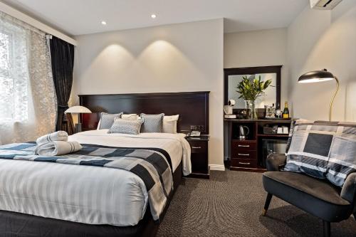 沃加沃加沃加沃加国际酒店的一间卧室配有一张大床和一把椅子