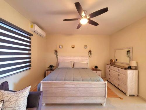 佩尼亚斯科港Earthy 2 Story Beach House!的一间卧室配有一张床和吊扇