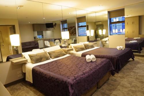 墨尔本Melbourne ViVo的酒店客房带两张床和大镜子